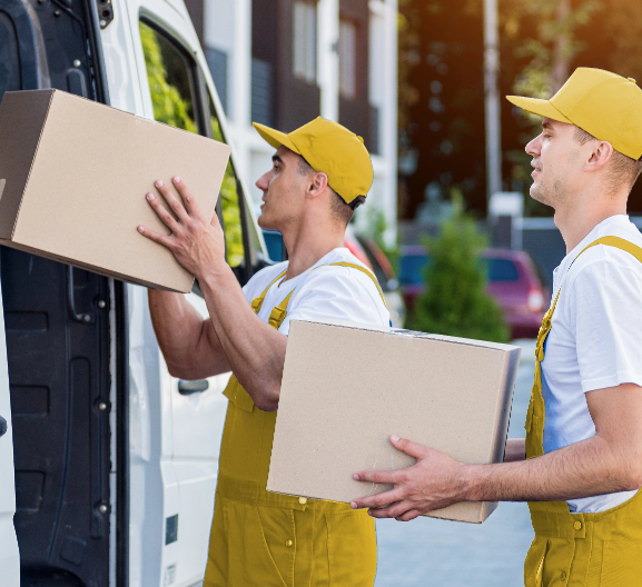 two removal company workers are loading boxes into minibus